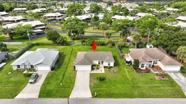 an aerial view of a house with swimming pool garden and patio