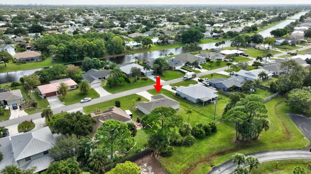 an aerial view of residential houses with outdoor space and trees