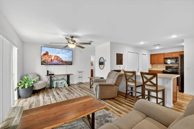 a living room with furniture kitchen view and a potted plant