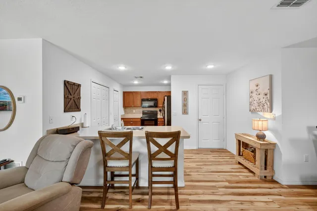 a living room with furniture a flat screen tv and a wooden floor