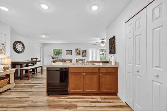 a large room with stainless steel appliances granite countertop a dishwasher kitchen island a stove and a refrigerator with wooden floor