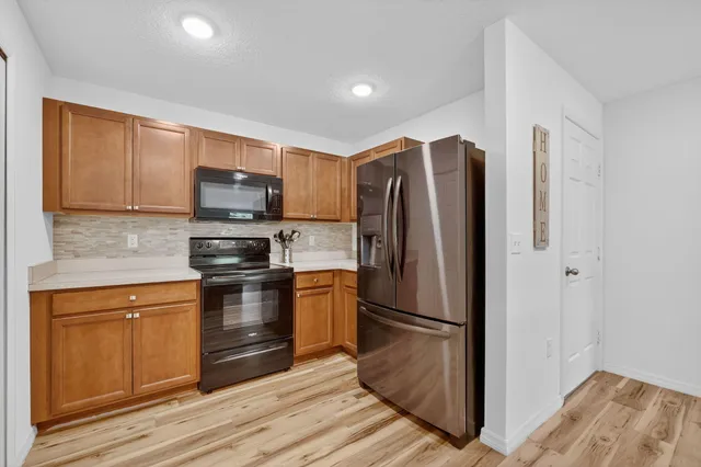 a kitchen with stainless steel appliances granite countertop a refrigerator stove and sink