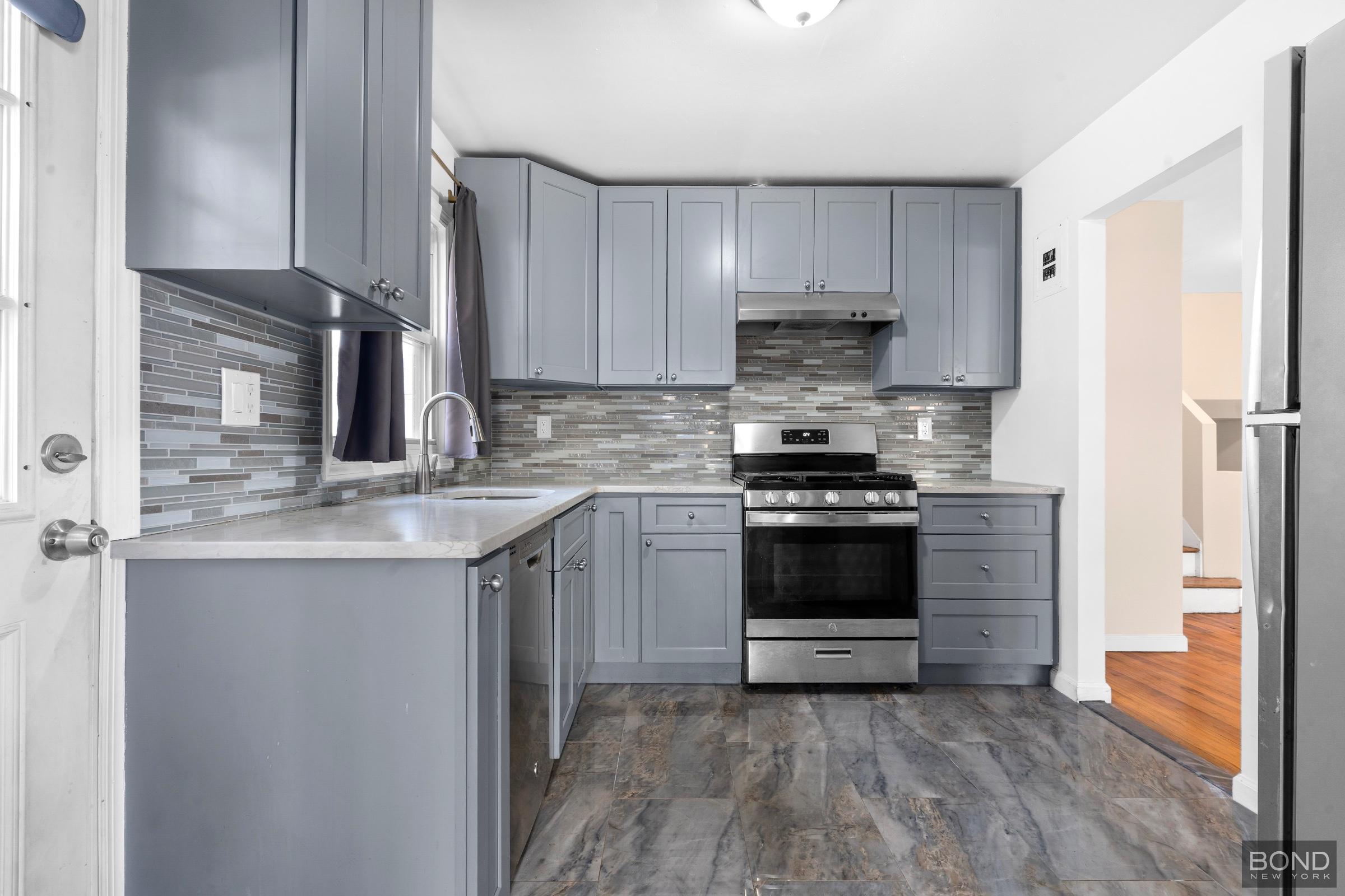 15-47 209th Street Queens, NY 11360 - Photo 4 of 11 a kitchen with a stove and a refrigerator