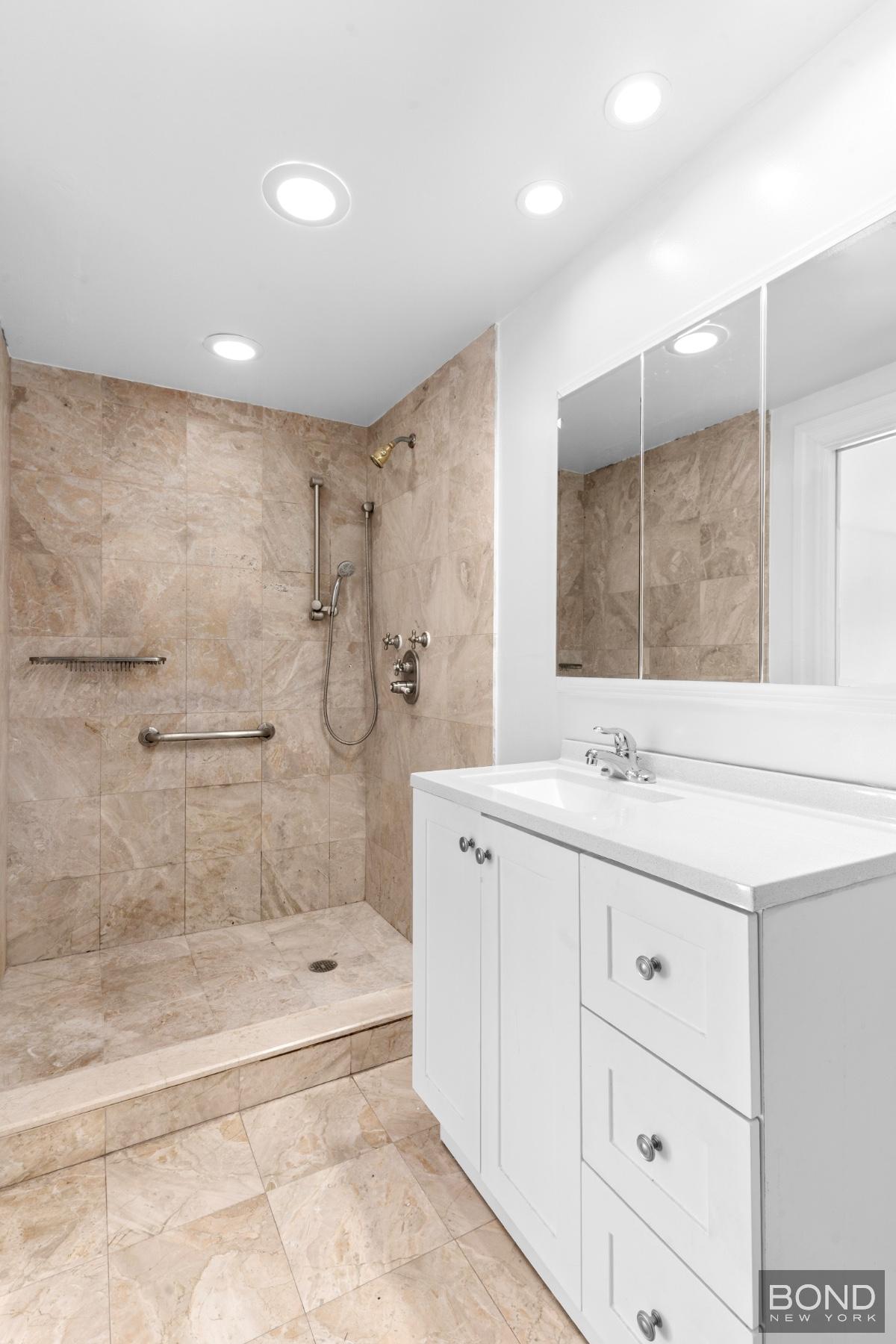 15-47 209th Street Queens, NY 11360 - Photo 8 of 11 a bathroom with a granite countertop sink a toilet a mirror and shower