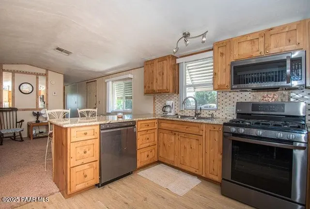 a kitchen with stainless steel appliances granite countertop a stove and a sink