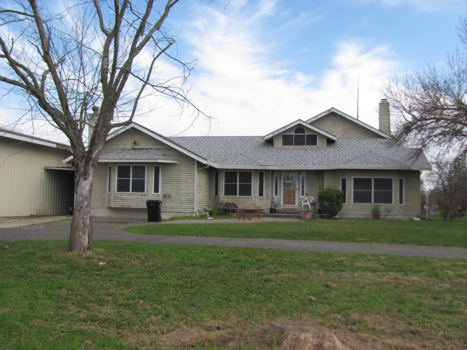 a front view of a house with a garden and trees