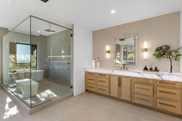 a bathroom with a double vanity sink mirror and bathtub