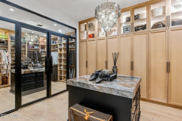 a view of walk in closet with clothes and shoes