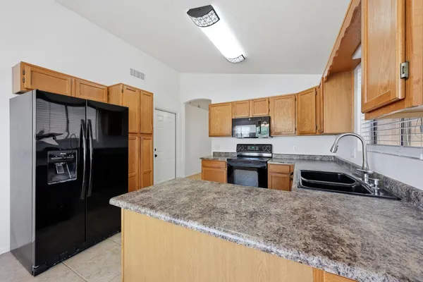 a view of an empty room and chandelier fan