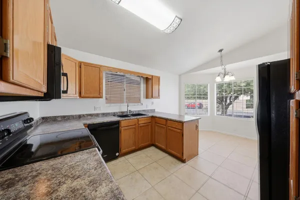a kitchen with stainless steel appliances granite countertop a stove a sink and a refrigerator