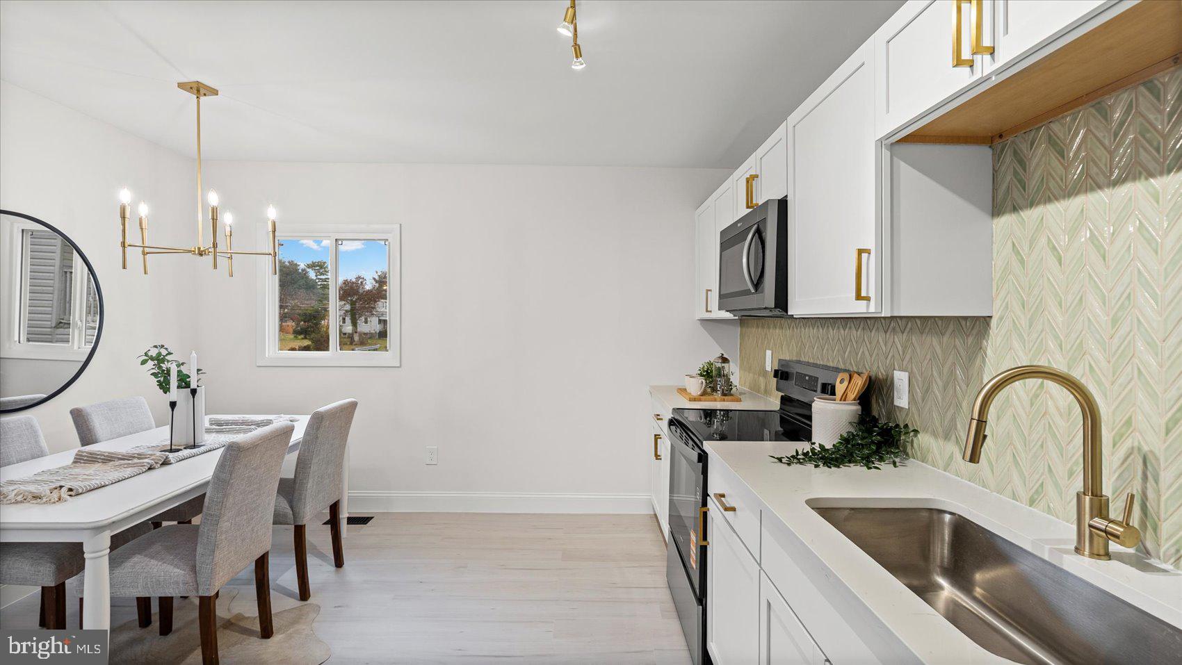4817 Valley Forge Road Randallstown, MD 21133 - Photo 23 of 36 a kitchen with stainless steel appliances a sink a counter space and dining table