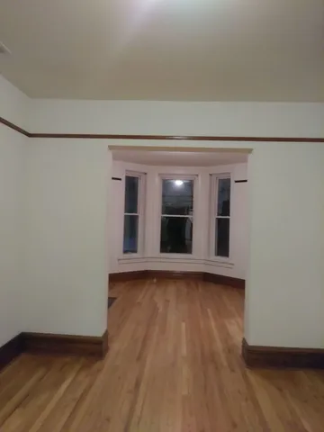 a view of a room with wooden floor and more window