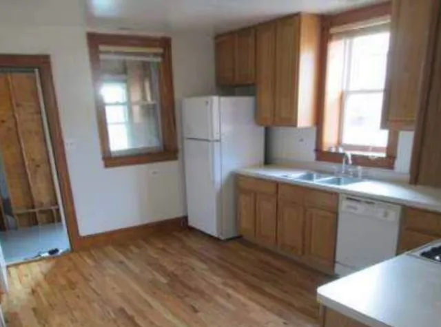a kitchen with sink cabinets and wooden floor
