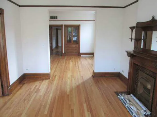 wooden floor in an empty room with a fireplace