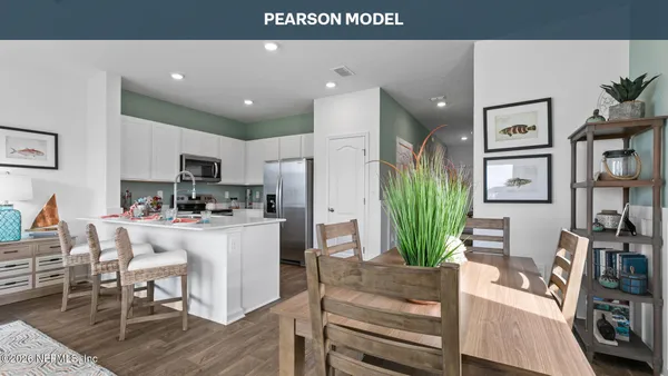 a living room with stainless steel appliances furniture a flat screen tv and a refrigerator