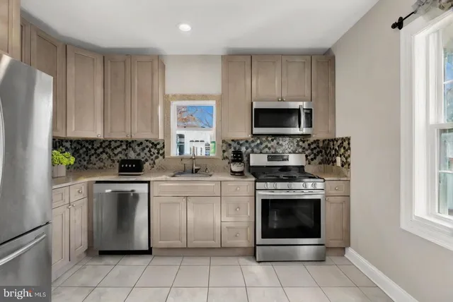 a kitchen with cabinets stainless steel appliances and a sink
