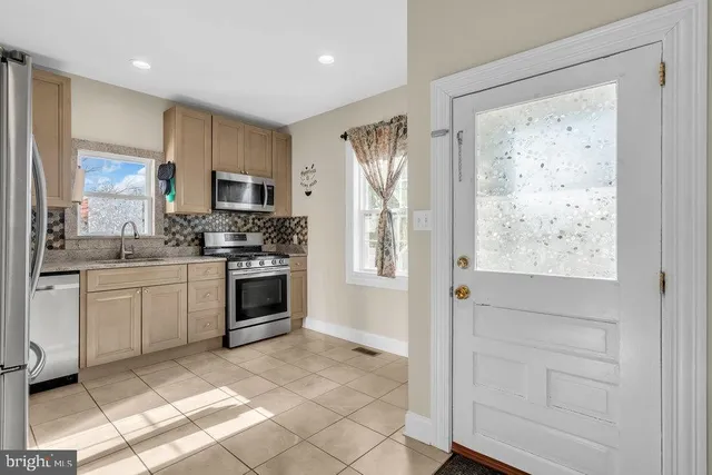 a kitchen with stainless steel appliances a refrigerator sink and microwave