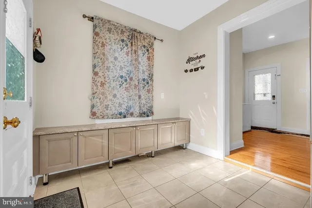 a spacious bathroom with a granite countertop sink a mirror and a bathtub