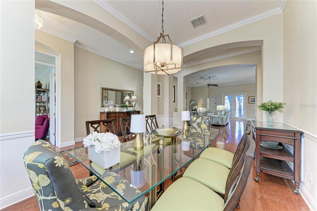 302 Cockle Shell Loop Apollo Beach, FL 33572 - Photo 13 of 75 a view of a dining room with furniture wooden floor and chandelier