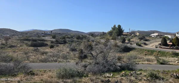 a view of a dry field with mountains in the background