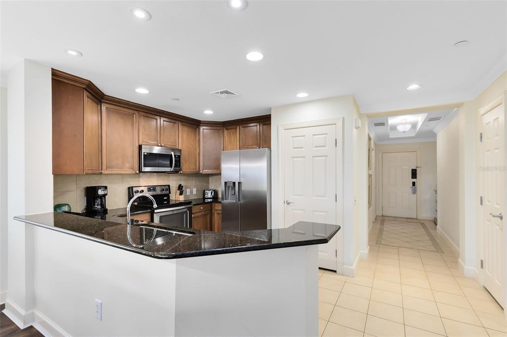1368 Centre Ct Ridge Drive, Unit 104 Reunion, FL 34747 - Photo 11 of 33 a kitchen with stainless steel appliances granite countertop a sink a refrigerator and a granite counter tops