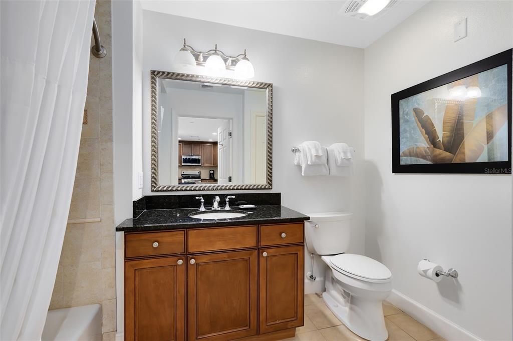 1368 Centre Ct Ridge Drive, Unit 104 Reunion, FL 34747 - Photo 23 of 33 a bathroom with a granite countertop sink a toilet and mirror