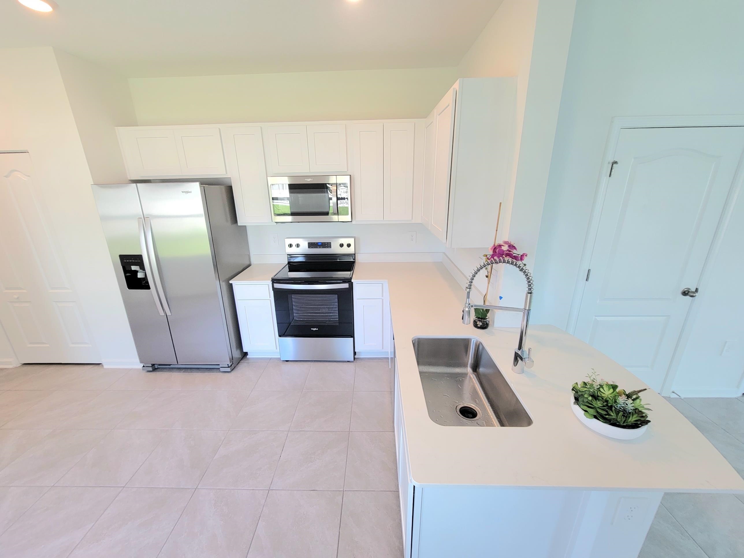 177 Tidal Bch Avenue St. Augustine, FL 32095 - Photo 13 of 39 a kitchen with stainless steel appliances a sink a stove a microwave a refrigerator a counter top space and cabinets