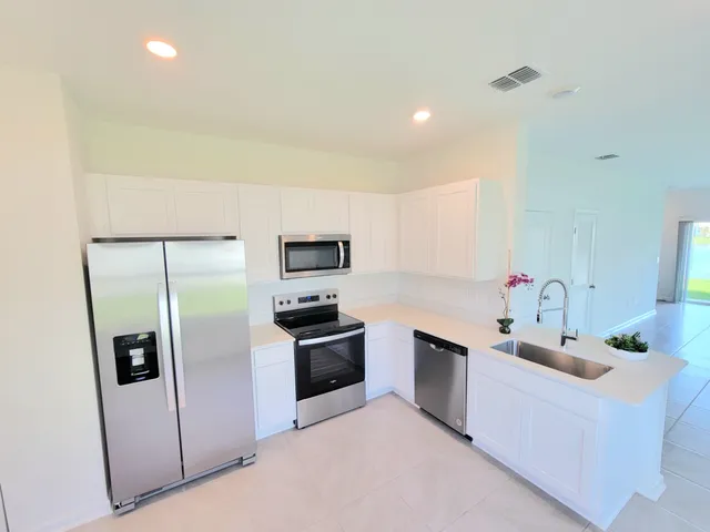 a kitchen with stainless steel appliances granite countertop a refrigerator sink and stove