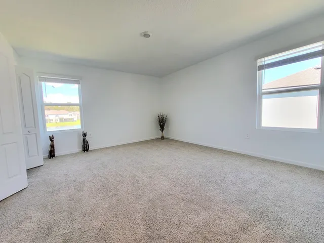 an empty room with a window and wooden floor