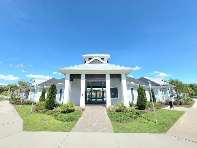 a front view of a house with a yard and potted plants