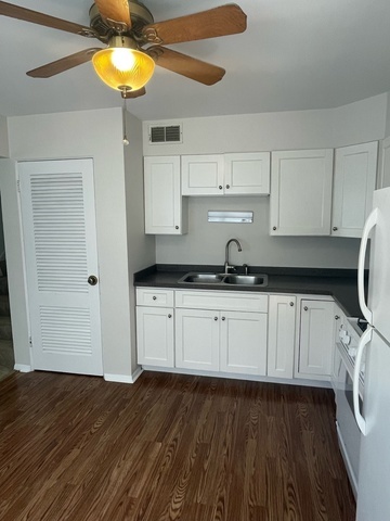 961 Spring Road Elmhurst, IL 60126 - Photo 13 of 24 a kitchen with a wooden floor and white appliances