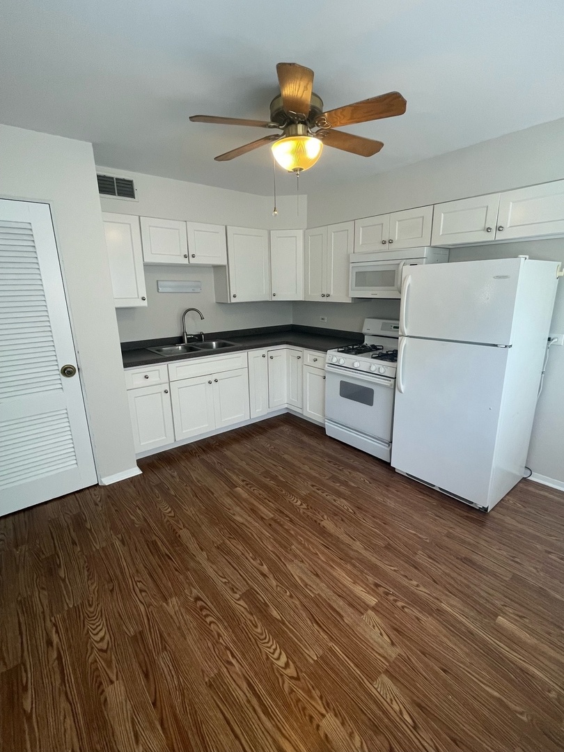 961 Spring Road Elmhurst, IL 60126 - Photo 14 of 24 a kitchen with a sink stainless steel appliances wooden floor and cabinets