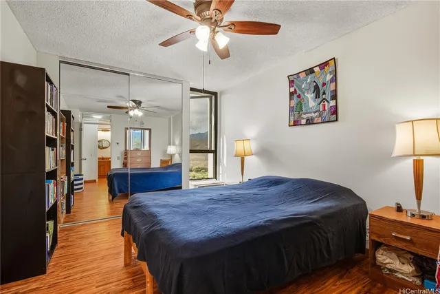a spacious bedroom with a bed dresser and a chandelier