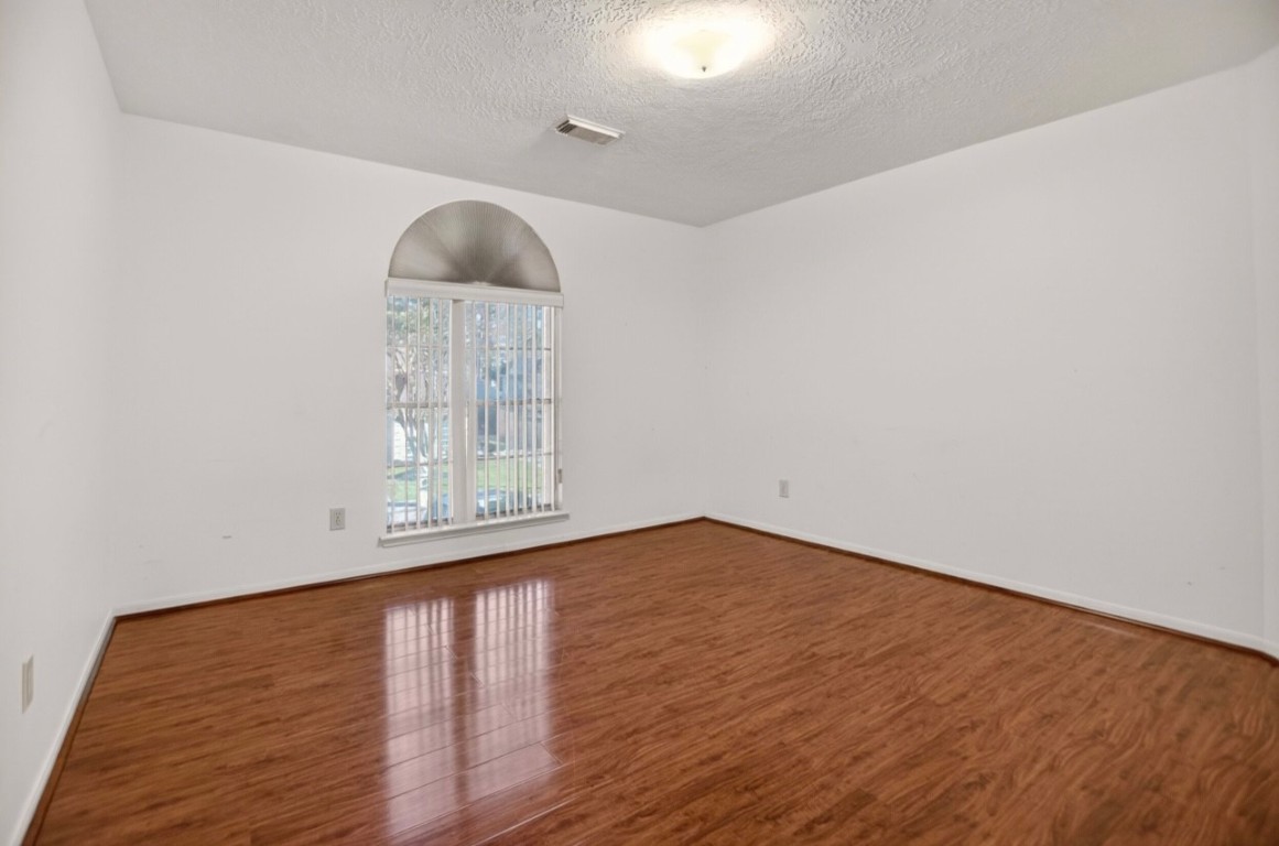 14731 Ridgechase Lane Houston, TX 77014 - Photo 9 of 29 a view of an empty room with wooden floor and a window
