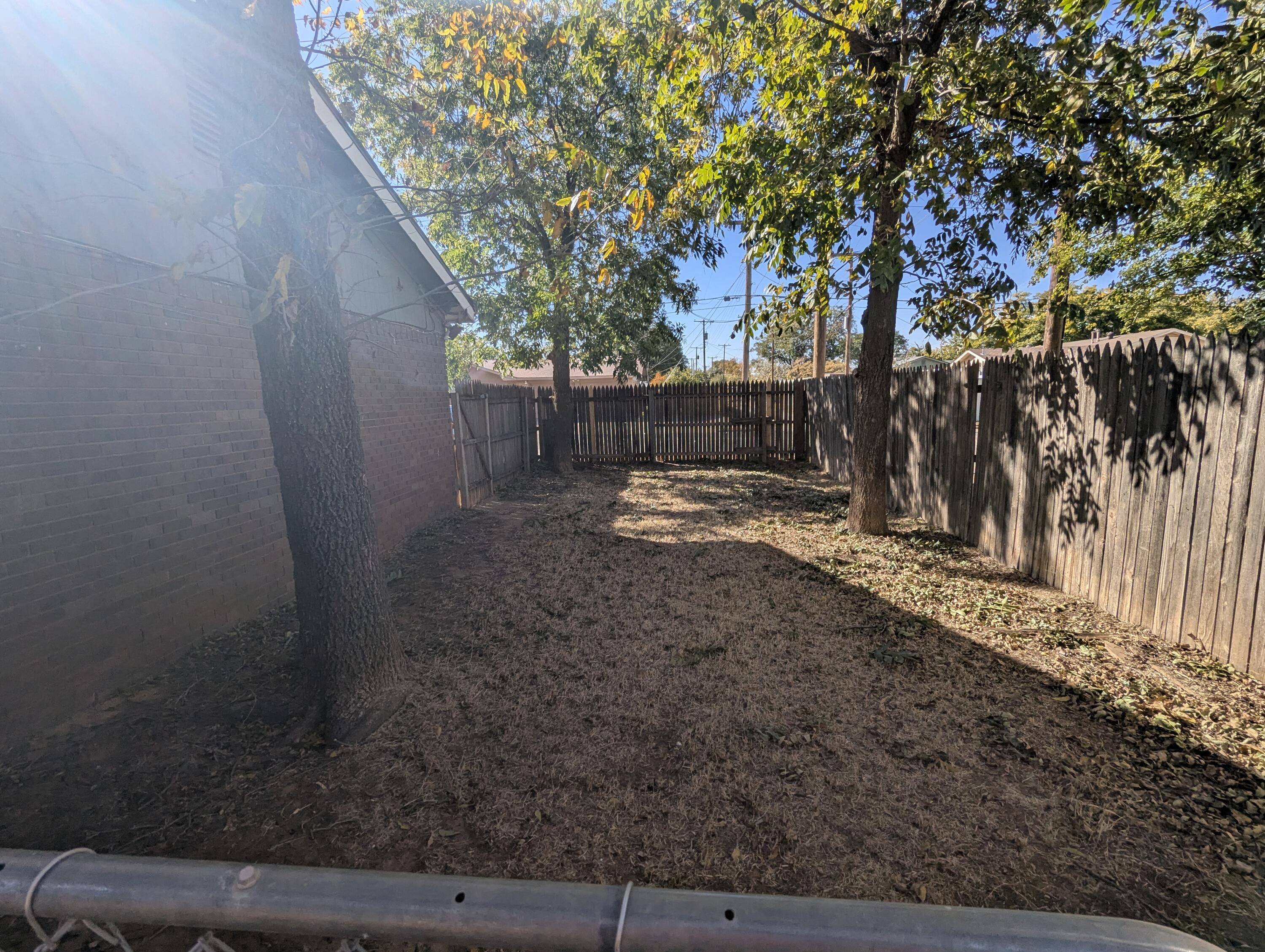 5416 36th Street Lubbock, TX 79407 - Photo 12 of 13 a view of a backyard with large trees