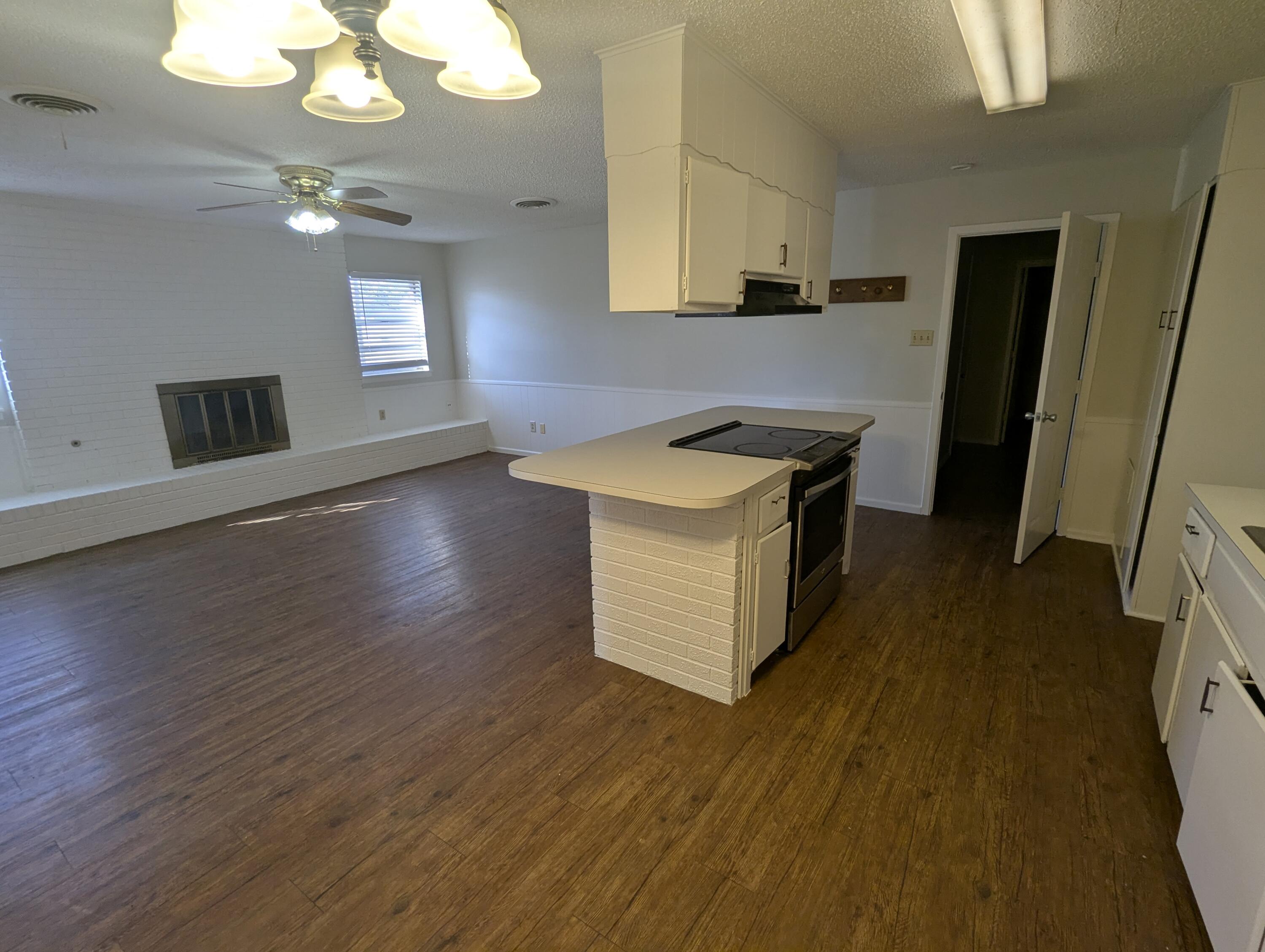 5416 36th Street Lubbock, TX 79407 - Photo 3 of 13 a kitchen with stainless steel appliances granite countertop a sink a stove a refrigerator and island with wooden floor