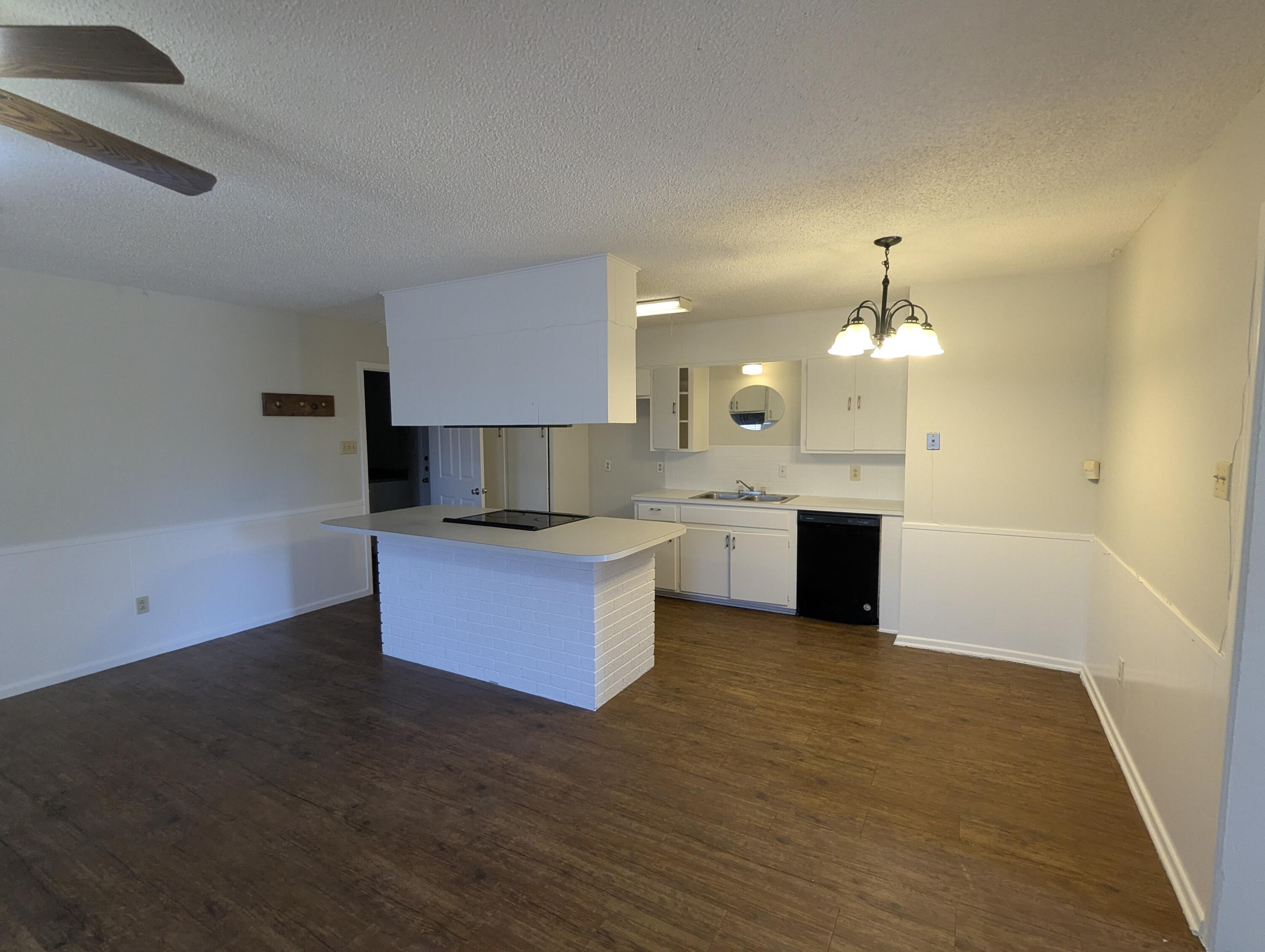 5416 36th Street Lubbock, TX 79407 - Photo 4 of 13 a large kitchen with stainless steel appliances a large counter top a stove and a wooden floor