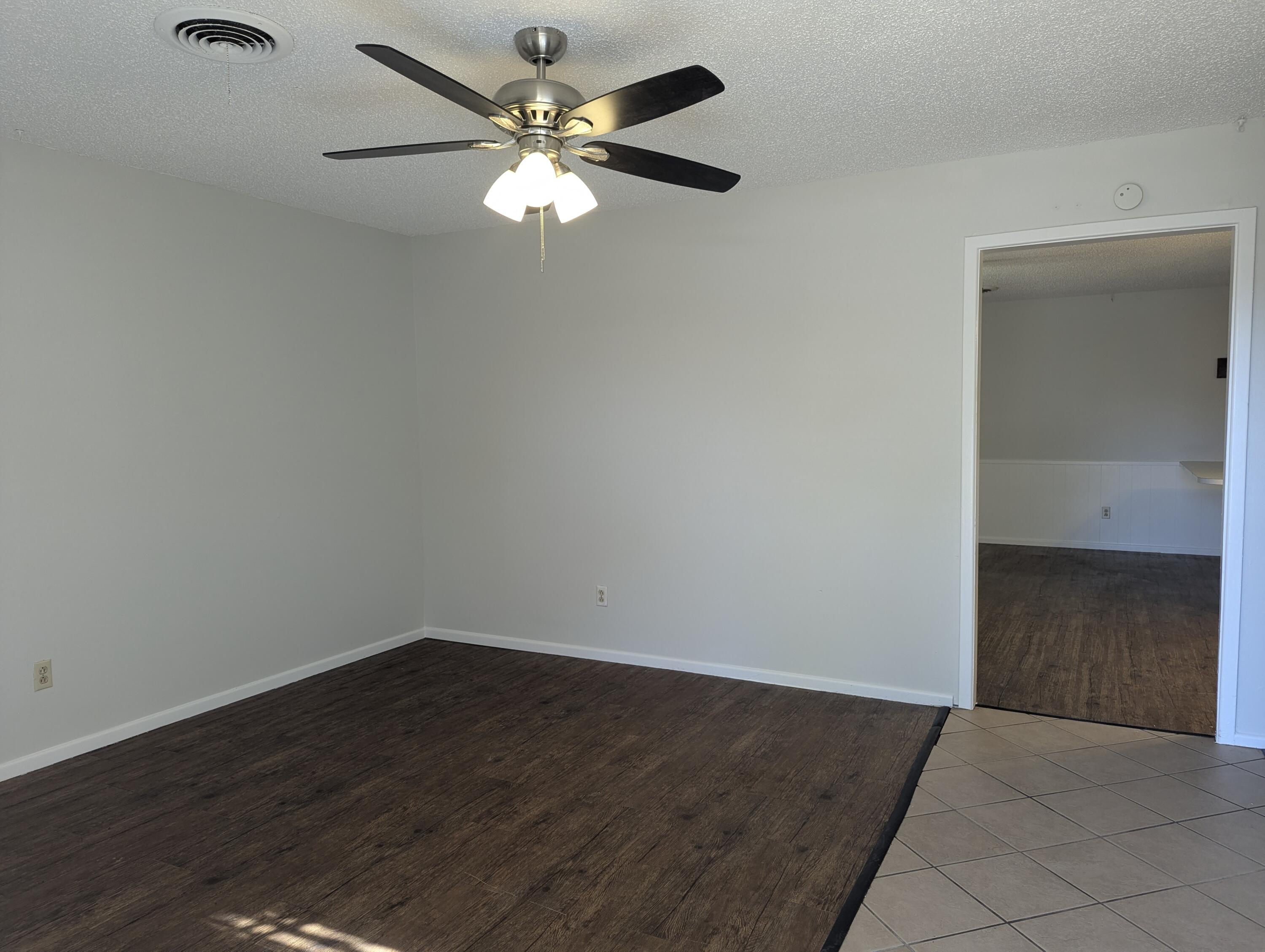 5416 36th Street Lubbock, TX 79407 - Photo 5 of 13 an empty room with wooden floor chandelier fan and windows