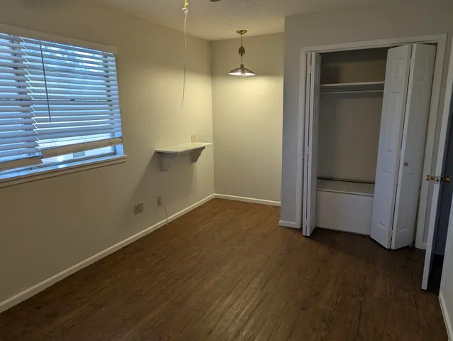 an empty room with wooden floor and door