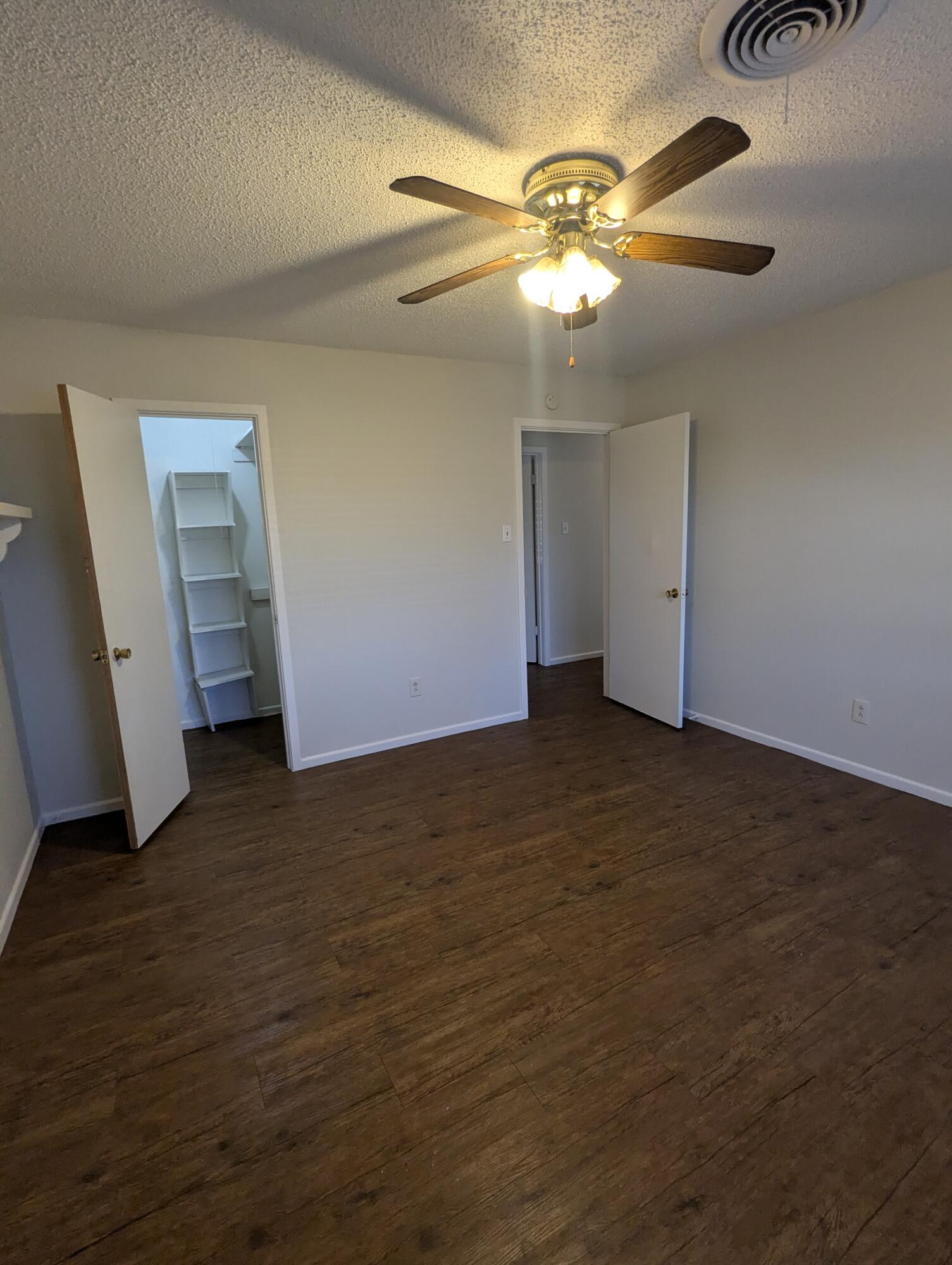 5416 36th Street Lubbock, TX 79407 - Photo 9 of 13 a view of an empty room with wooden floor and a ceiling fan
