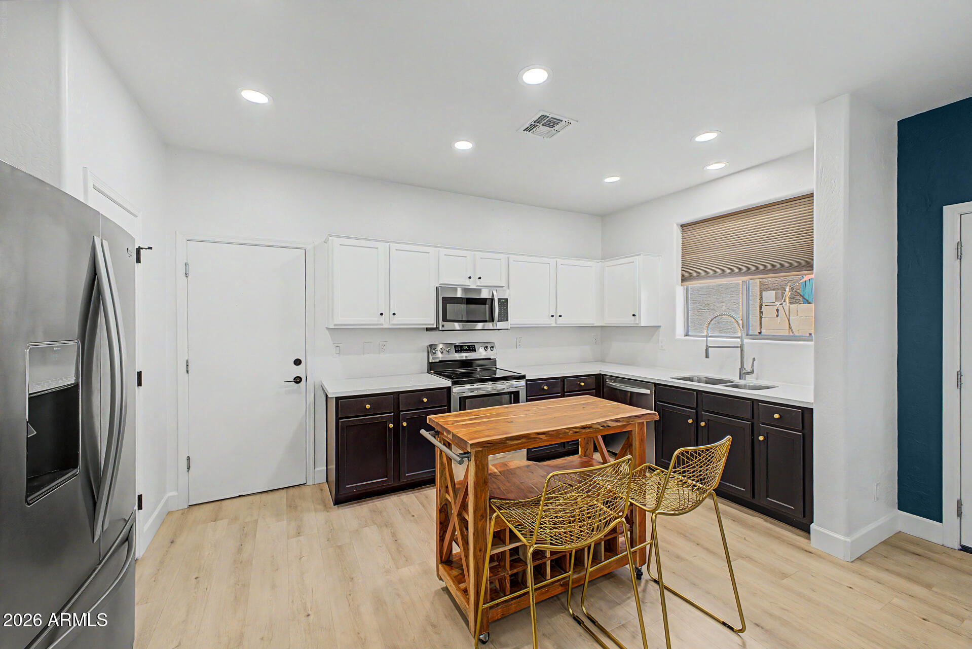451 South Hawes Road, Unit 27 Mesa, AZ 85208 - Photo 7 of 27 a kitchen with stainless steel appliances granite countertop a stove a sink a microwave a island with a dining table and chairs