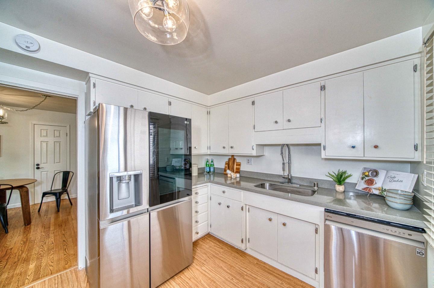 760 University Avenue Palo Alto, CA 94301 - Photo 11 of 25 a kitchen with granite countertop a refrigerator a sink a stove and white cabinets