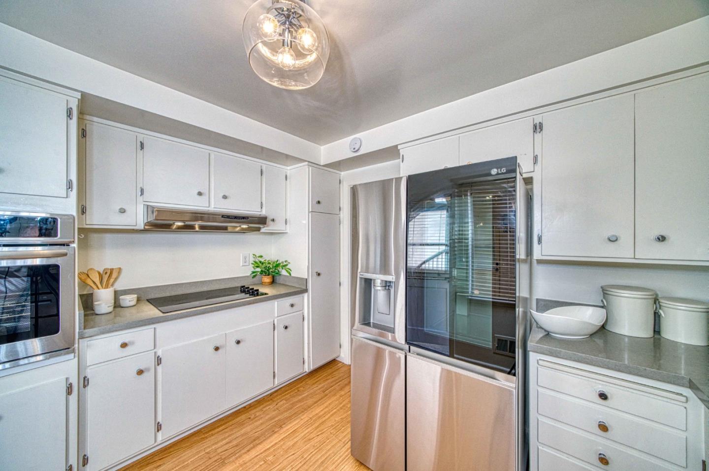 760 University Avenue Palo Alto, CA 94301 - Photo 10 of 25 a kitchen with stainless steel appliances granite countertop a refrigerator and white cabinets