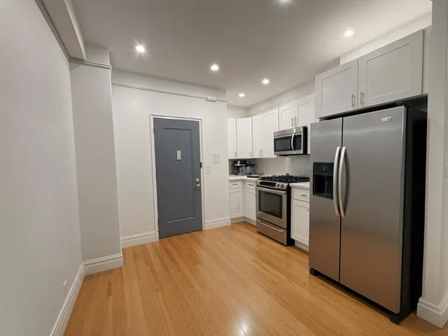 a kitchen with stainless steel appliances a refrigerator and a stove top oven