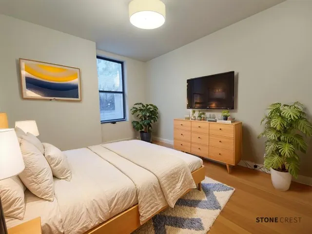 a bedroom with a bed and a flat screen tv