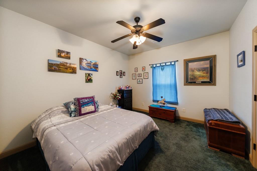 433 Fruitland Road Bowie, TX 76230 - Photo 14 of 40 a bedroom with a bed and a chandelier