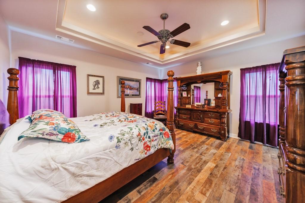 433 Fruitland Road Bowie, TX 76230 - Photo 21 of 40 a bedroom with a bed and dresser with wooden floor