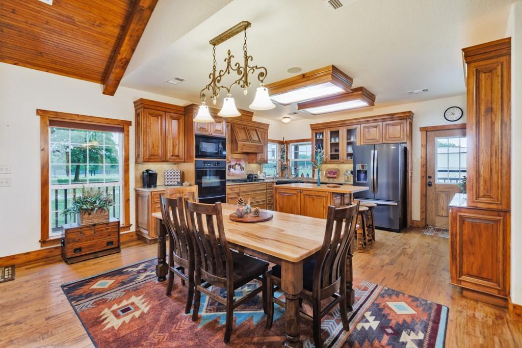 433 Fruitland Road Bowie, TX 76230 - Photo 3 of 40 a dining room with furniture a rug and wooden floor