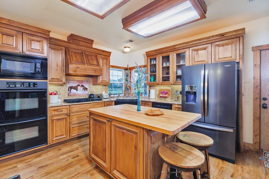 433 Fruitland Road Bowie, TX 76230 - Photo 5 of 40 a kitchen with stainless steel appliances granite countertop a stove refrigerator and a refrigerator