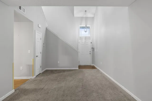 a living room with furniture kitchen view and a chandelier